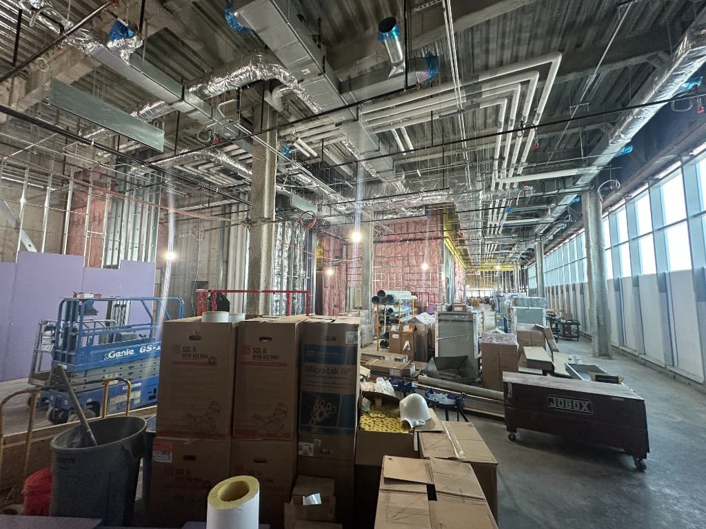Construction site with overhead MEP systems and materials